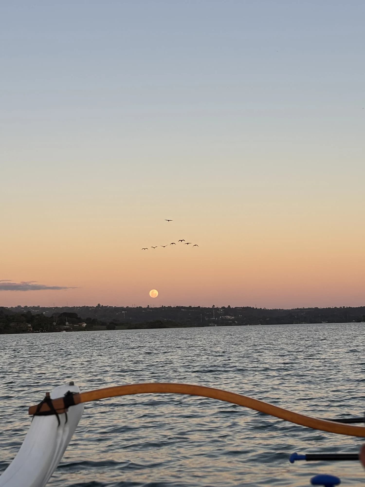Lua cheia próxima ao horizonte sobre o Lago Paranoá