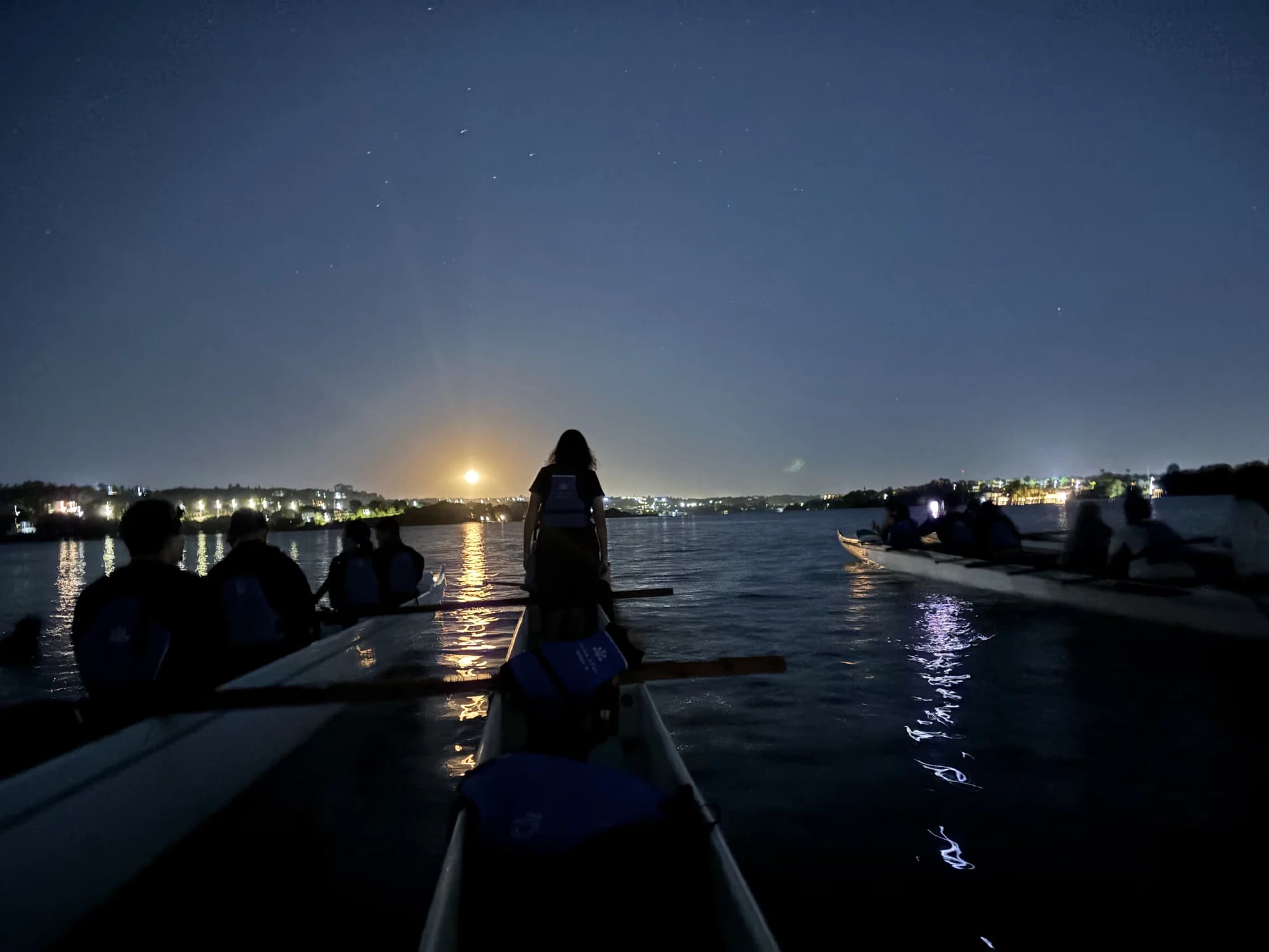 Remada noturna sob a lua cheia e seu reflexo no lago