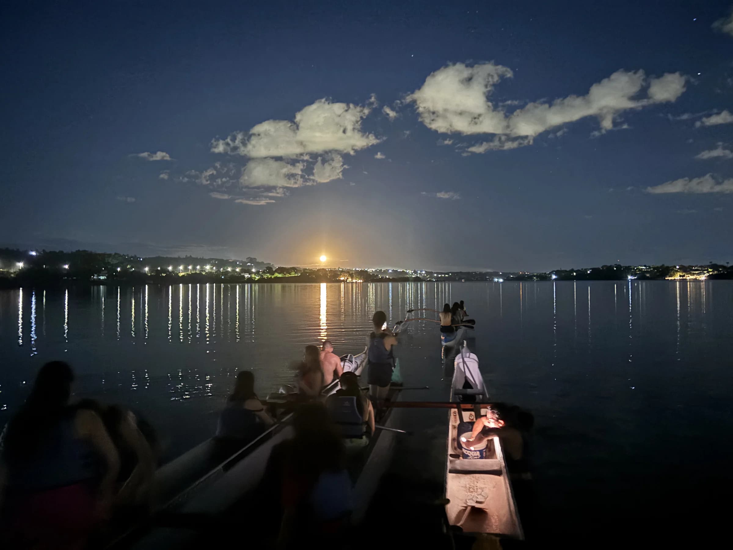 Lua cheia refletida no Lago Paranoá diante de canoas havaianas