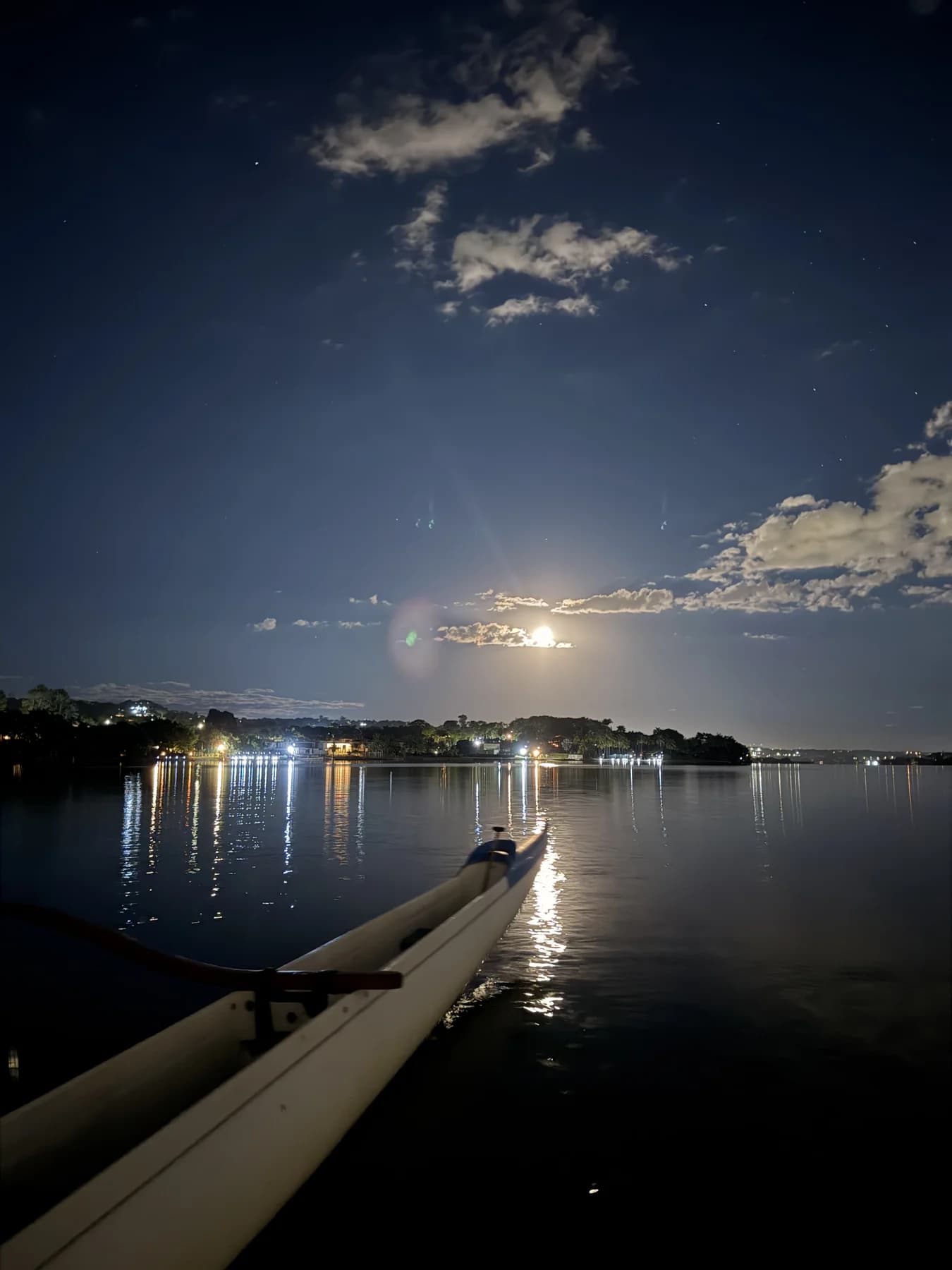 Lua cheia refletida no Lago Paranoá ao lado de uma canoa havaiana