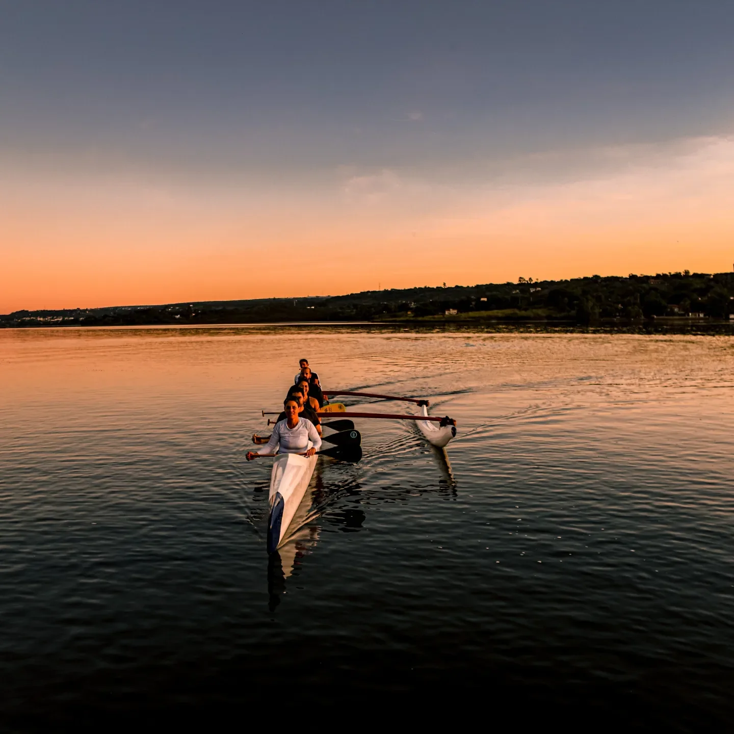 Canoa havaiana vista de frente nas águas do Lago Paranoá ao amanhecer