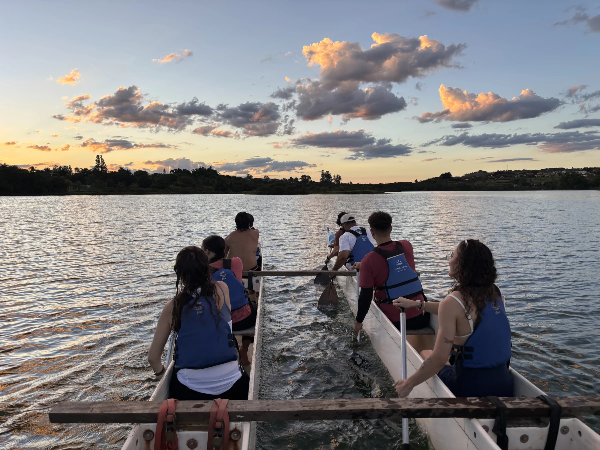 Participantes remando juntos em uma canoa havaiana no Lago Paranoá