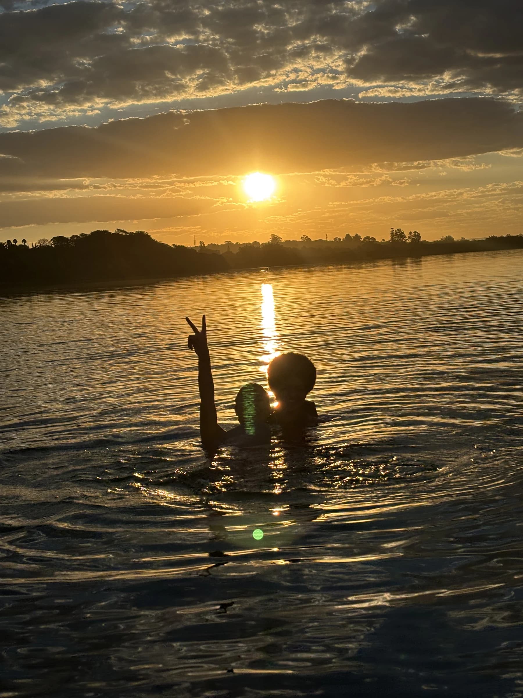 Participantes tomando banho no Lago Paranoá durante o entardecer