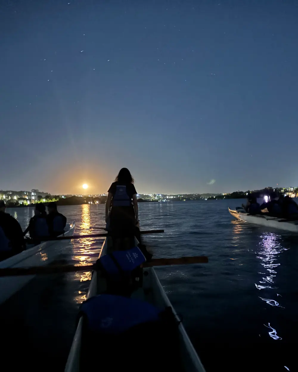 Canoas havaianas no Lago Paranoá com a lua cheia nascendo no horizonte