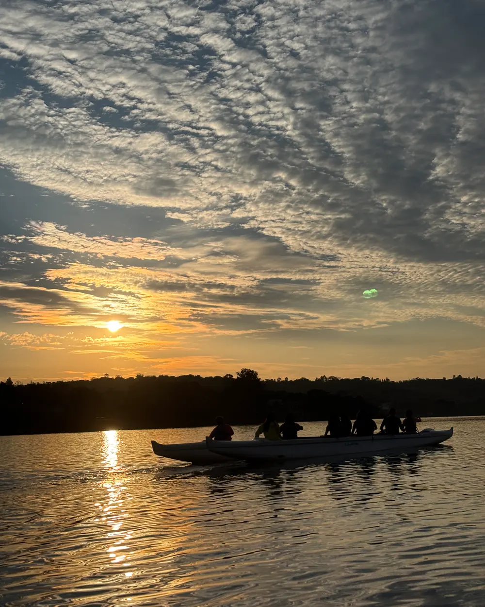 Silhueta de uma canoa havaiana ao nascer do sol no Lago Paranoá